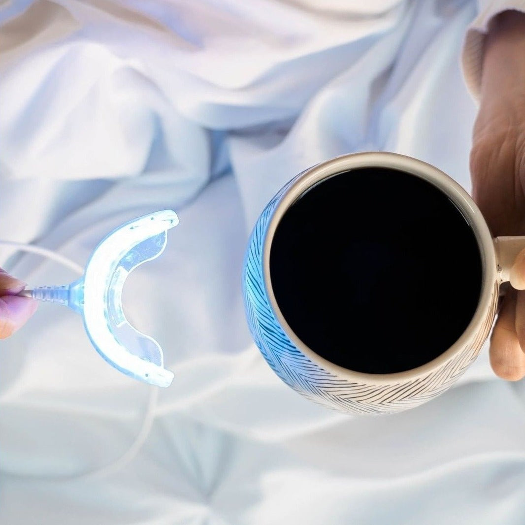 Woman holding NovaSmile Premium Teeth Whitening kit led mouthpiece next to her coffee